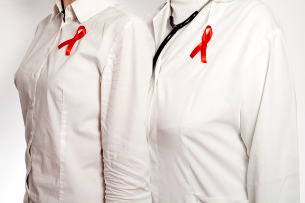 Médico e paciente com fitas vermelhas de conscientização da AIDS em seus peitos
 - Foto, Imagem