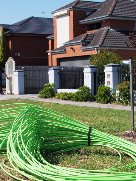 Câble à fibre optique verte empilé devant un logement résidentiel
 - Photo, image