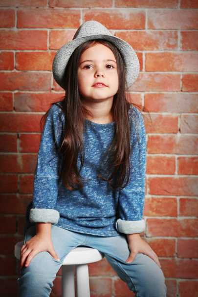 Portrait of little fashion kid girl on bricks wall background - Foto, immagini