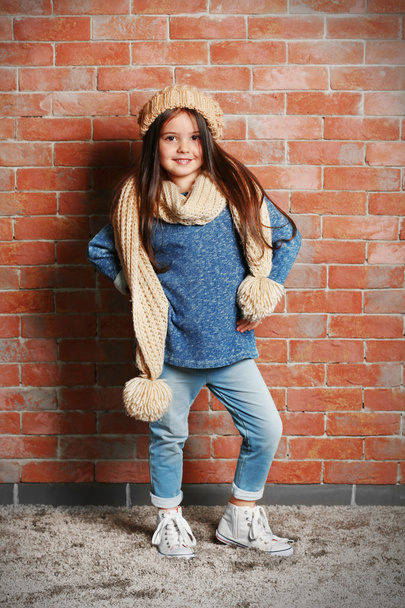 Portrait of little fashion kid girl on bricks wall background - Foto, Imagen