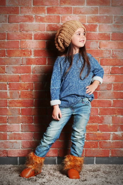 Portrait of little fashion kid girl on bricks wall background - Photo, image