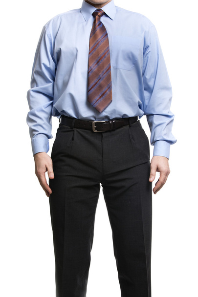Liikemies sinisessä paidassa seisoo kädet lantiolla
 - Valokuva, kuva