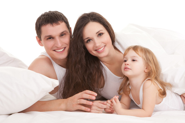 Happy family, mother, father and daughter resting on the white b - Фото, зображення