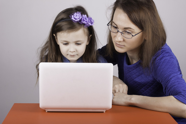 nainen opettaa lapselle työtä tietokoneella
 - Valokuva, kuva