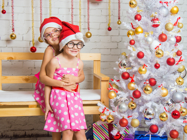 das Mädchen umarmte seine Schwester im neuen Jahr zu Hause - Foto, Bild