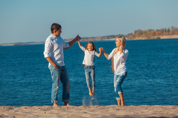 glückliche Familie, die am Strand spielt. Konzept freundlicher Familien - Foto, Bild