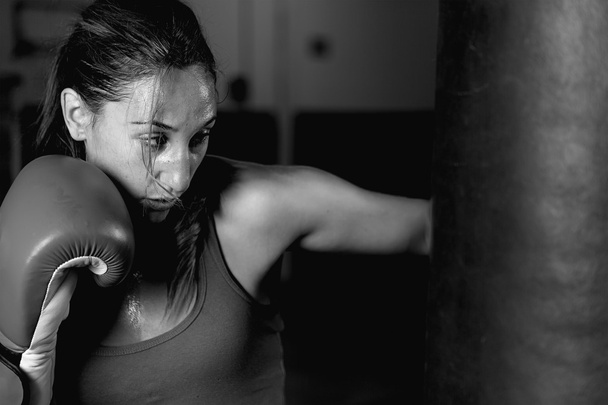Primer plano de la atleta profesional practicando golpes en el saco de boxeo
 - Foto, imagen