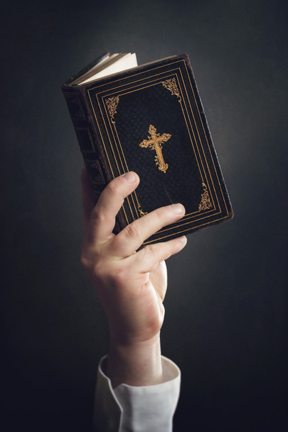 Man holding a Bible in the air - Zdjęcie, obraz