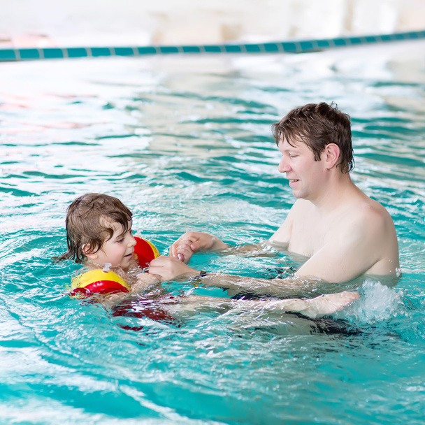 Petit garçon et son père nagent dans une piscine intérieure
 - Photo, image