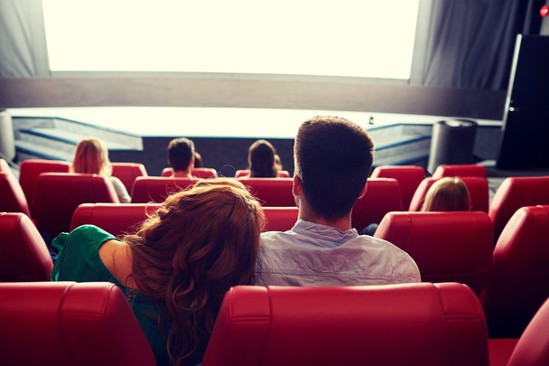 happy couple watching movie in theater or cinema - Foto, afbeelding