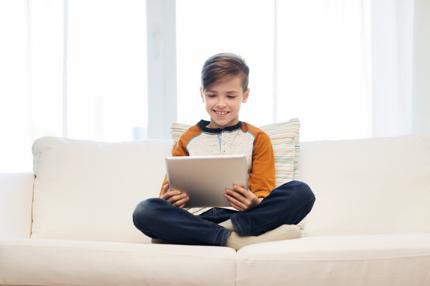 uśmiechnięty chłopiec z komputera typu tablet w domu - Zdjęcie, obraz