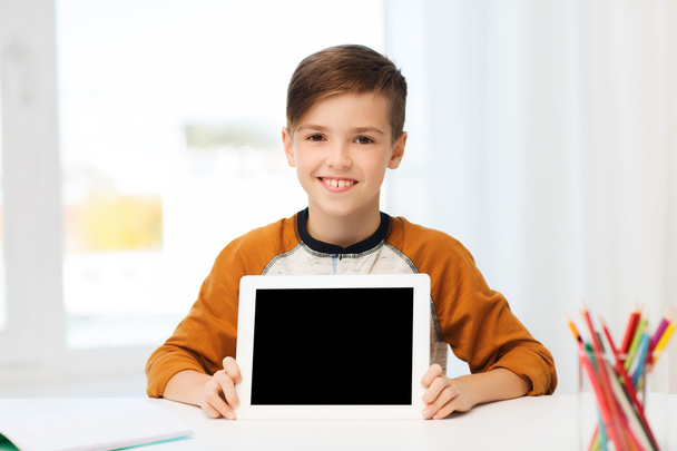 smiling boy showing tablet pc blank screen at home - Foto, Imagen