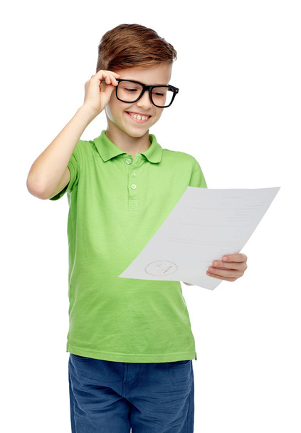 happy boy in eyeglasses holding school test result - Foto, Imagen