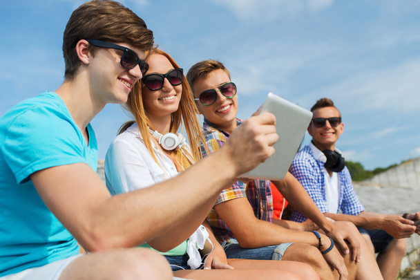 group of smiling friends with tablet pc outdoors - Foto, Bild