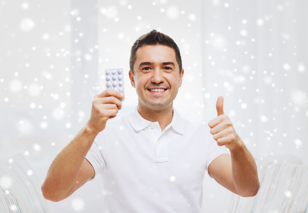 homem feliz com pacote de comprimidos mostrando polegares para cima
 - Foto, Imagem