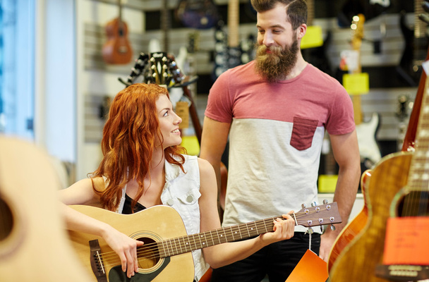 couple of musicians with guitar at music store - Foto, Bild