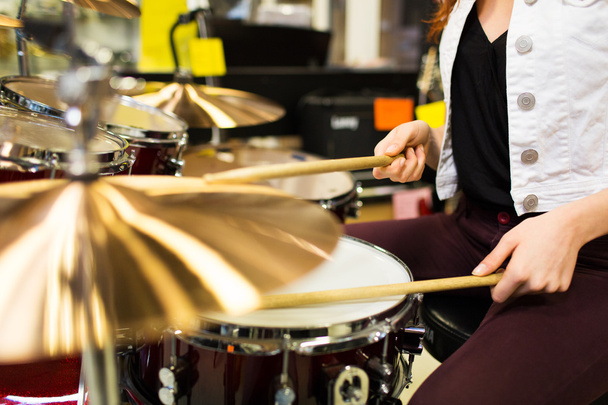 close up of woman playing cymbals at music store - Fotoğraf, Görsel
