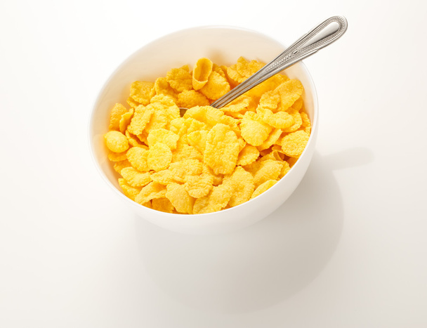 Copos de maíz amarillo sobre blanco
 - Foto, Imagen