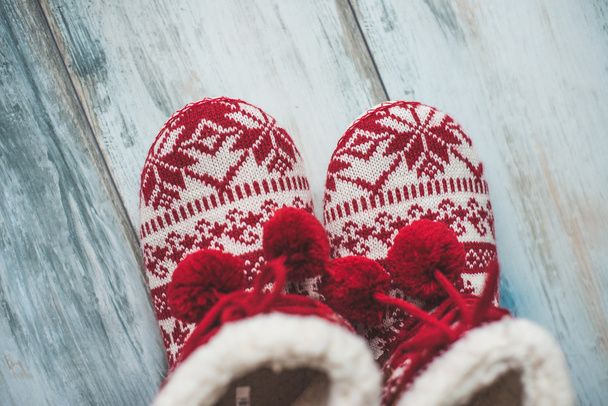 Cozy Christmas slippers on vintage wooden floor - Fotó, kép