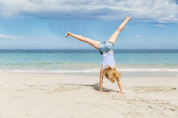 Nuori nainen hyppää rannalla
 - Valokuva, kuva