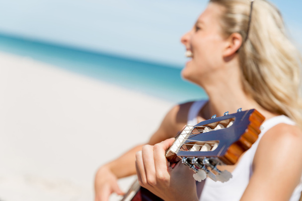 Beautiful young woman playing guitar on beach - Фото, зображення