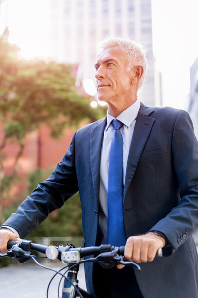 Successful businessman riding bicycle - Zdjęcie, obraz