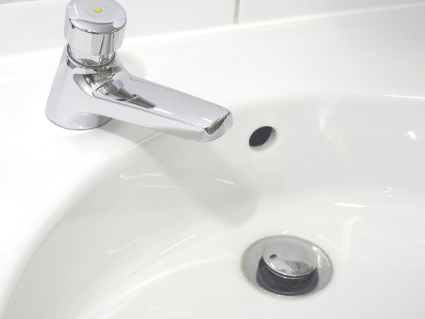 Раковина для мытья рук и носик в нетронутом промышленном туалете
 - Фото, изображение