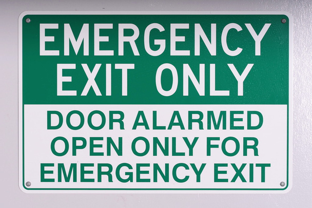 Sinal de parede de saída de emergência em verde no branco desligado
 - Foto, Imagem