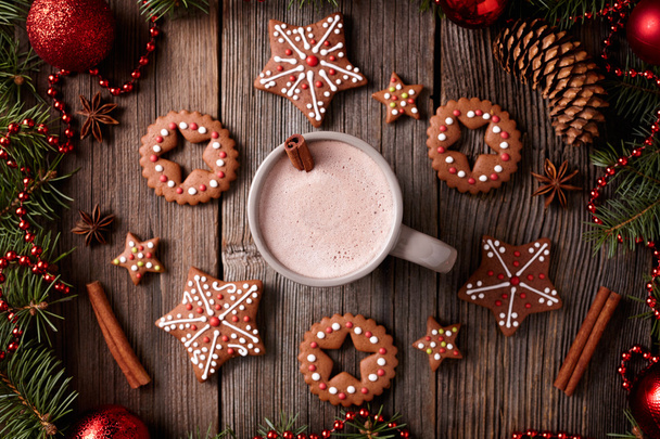 Cup of hot chocolate or cocoa with stars and round gingerbread cookies composition in new year decoration frame on vintage wooden table background. Homemade traditional recipe. - Foto, Imagen