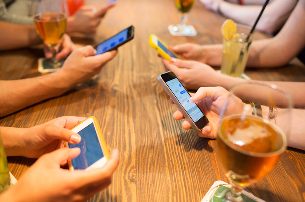 close up of hands with smartphones at restaurant - Foto, afbeelding