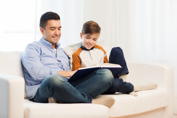 happy father and son reading book at home - Foto, Imagem