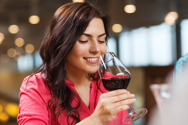 smiling woman drinking red wine at restaurant - Foto, Imagem