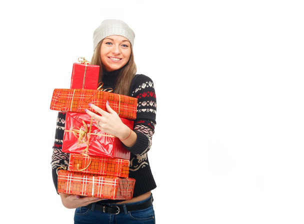 Woman in a winter sweater holding boxes with gifts. - Фото, изображение