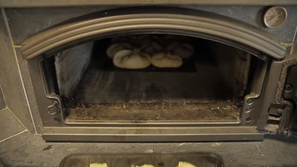Los pasteles en una bandeja para hornear se colocan en el horno para hornear
 - Metraje, vídeo
