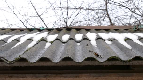 Αποψυχθεί. Νερό από τήξη χιονιού και πάγου στάζει από τη στέγη αμιάντου - Πλάνα, βίντεο