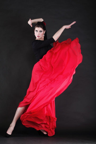 Attractive spanish young woman dancing flamenco over black backg - Фото, изображение
