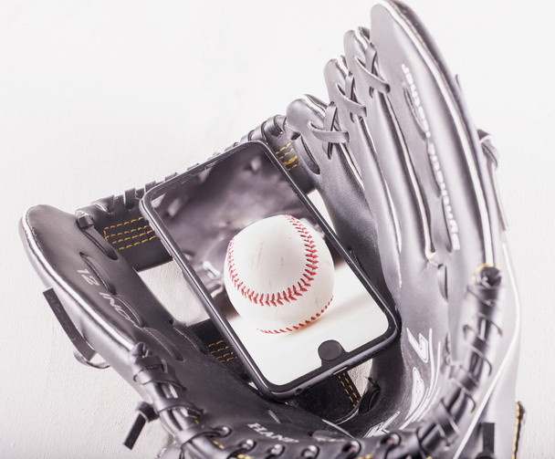 Baseball over smartphone in baseball glove - Фото, зображення