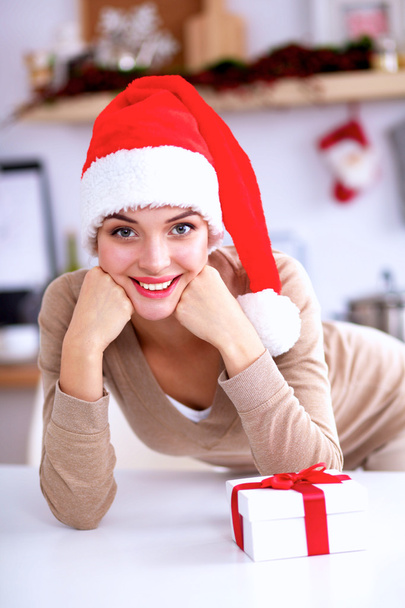 Smiling young woman in the kitchen, isolated on christmas background - Foto, Imagem