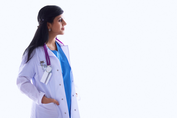 Doctor woman with stethoscope standing near wall - Фото, зображення