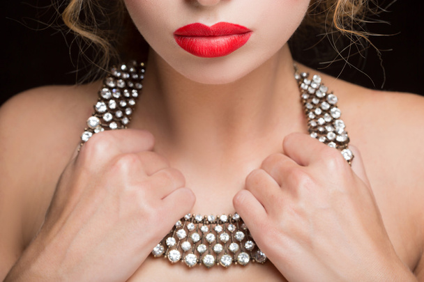 necklace on female neck. girl holding hands. sexy red lips. close-up - Photo, Image