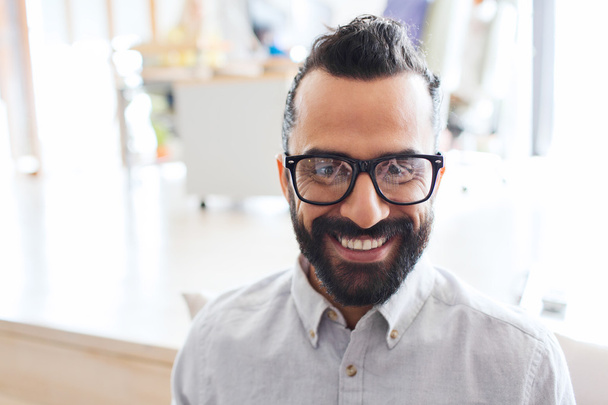 smiling man with eyeglasses and beard at office - Fotó, kép
