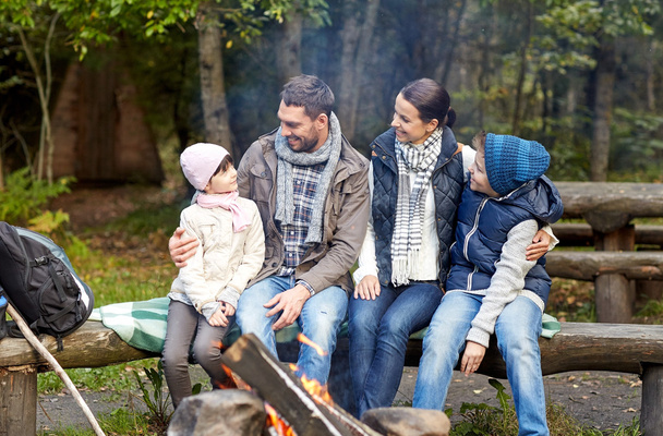 happy family sitting on bench at camp fire - Photo, image