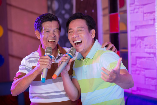 Aasian miehet nauttivat karaoke
 - Valokuva, kuva