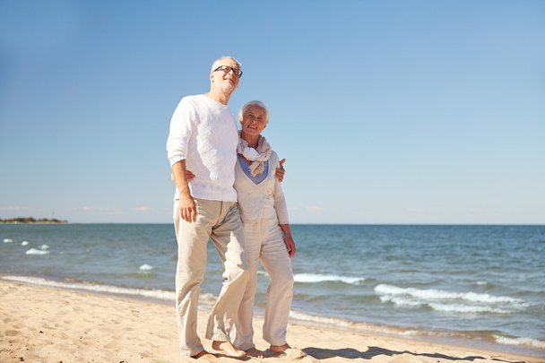 счастливая пожилая пара, гуляющая по летнему пляжу
 - Фото, изображение