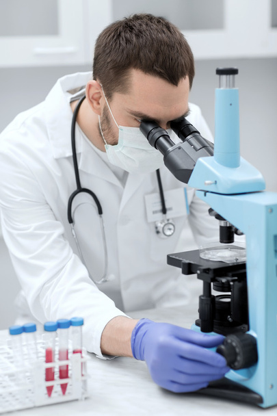 young scientist looking to microscope in lab - Photo, Image