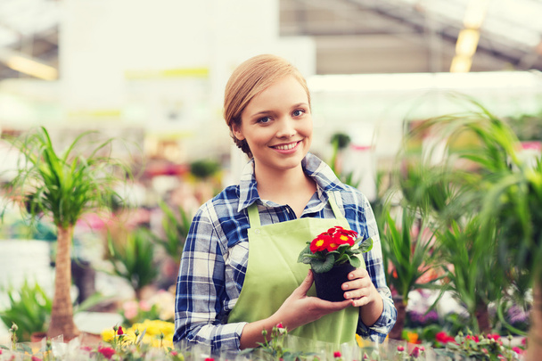happy woman holding flowers in greenhouse - Foto, imagen
