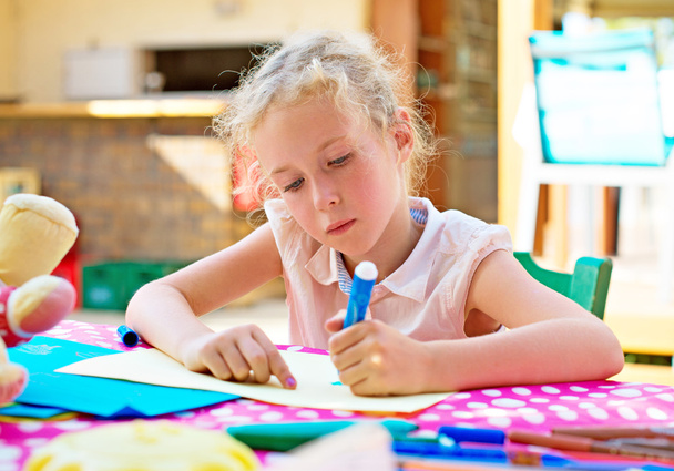 Милая маленькая девочка рисует маркером
. - Фото, изображение