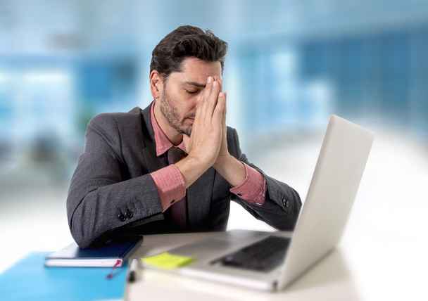 joven hombre de negocios sentado en la oficina trabajando en la computadora desesperado y preocupado en el estrés laboral
 - Foto, Imagen