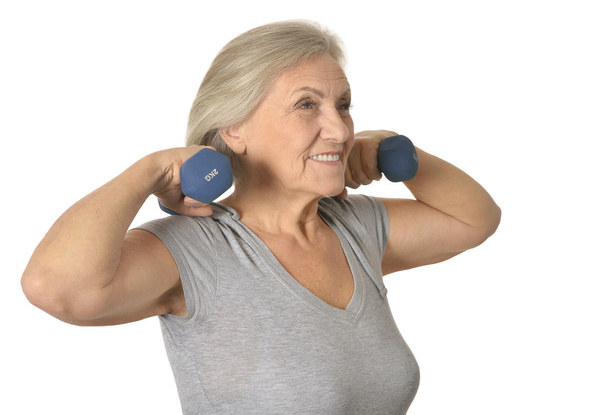 Senior woman exercising with dumbbells - Photo, image