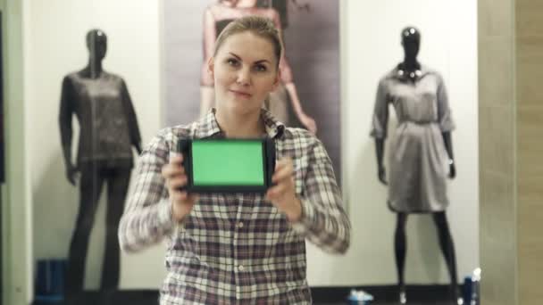 Dziewczyna pokazuje tabletki przy pomocy zielonego ekranu, w centrum handlowym - Materiał filmowy, wideo
